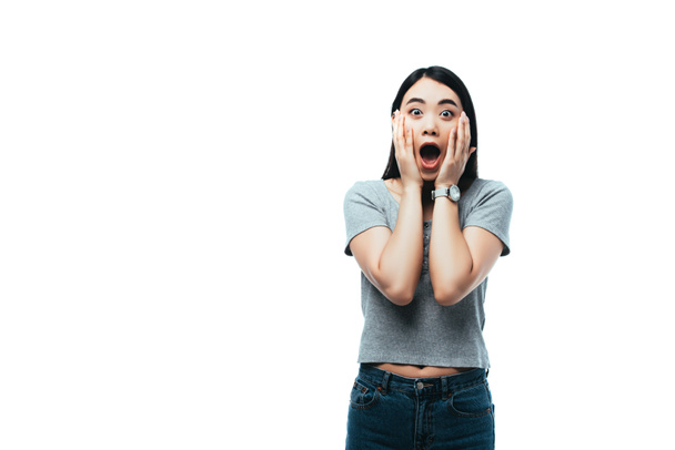 shocked asian girl with open mouth touching face isolated on white - 写真・画像
