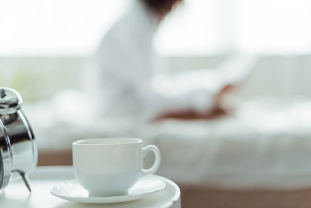 enfoque selectivo de la taza de café y platillo en el dormitorio por la mañana
   - Foto, imagen