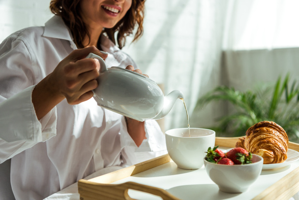 cropped view of woman pouring tea to cup at morning  - Photo, Image