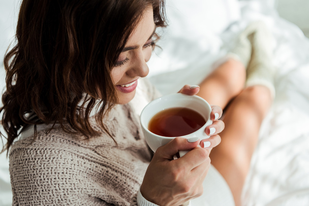 atractiva mujer en suéter gris sosteniendo taza de té por la mañana
  - Foto, Imagen