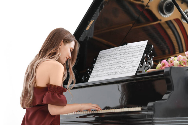 Молодая женщина играет на рояле на концерте
 - Фото, изображение