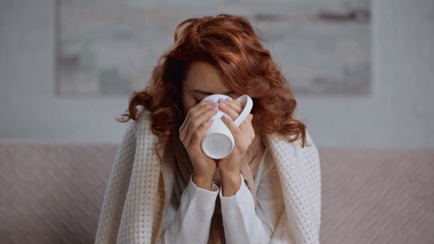 sick, upset woman covered with blanket drinking warming beverage - Footage, Video