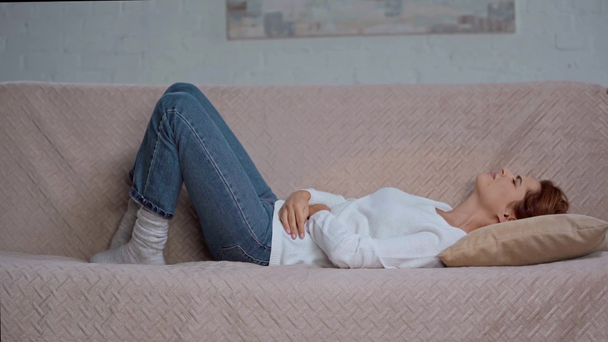 giovane donna sdraiata sul divano e affetta da dolore addominale
 - Filmati, video