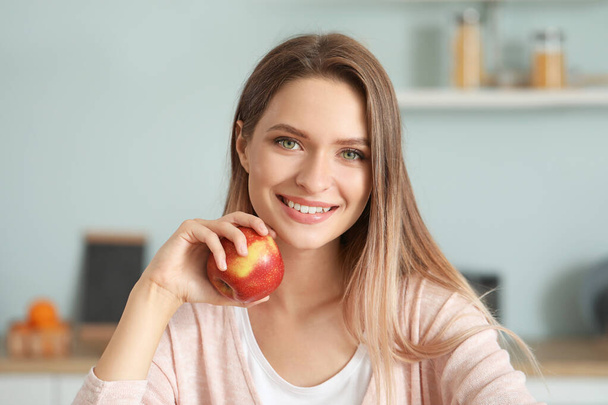 台所で健康的なリンゴを持つ女性。国会の概念 - 写真・画像