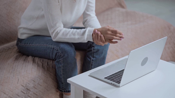 καλλιεργημένη άποψη της γυναίκας που αισθάνεται πόνο στον καρπό κατά τη χρήση laptop - Πλάνα, βίντεο