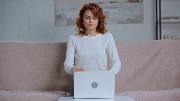 κουρασμένη γυναίκα που υποφέρει από πονοκέφαλο ενώ κάθεται κοντά στο laptop - Πλάνα, βίντεο