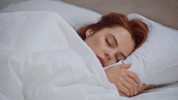 beautiful woman sleeping in bed under blanket - Materiał filmowy, wideo