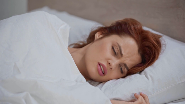 άρρωστη γυναίκα βήχει ξαπλωμένη στο κρεβάτι κάτω από κουβέρτα  - Πλάνα, βίντεο