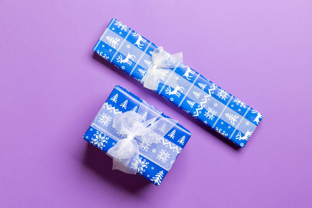 Κουτί δώρου με λευκό φιόγκο για τα Χριστούγεννα ή την Πρωτοχρονιά σε μωβ φόντο, κορυφαία προβολή - Φωτογραφία, εικόνα