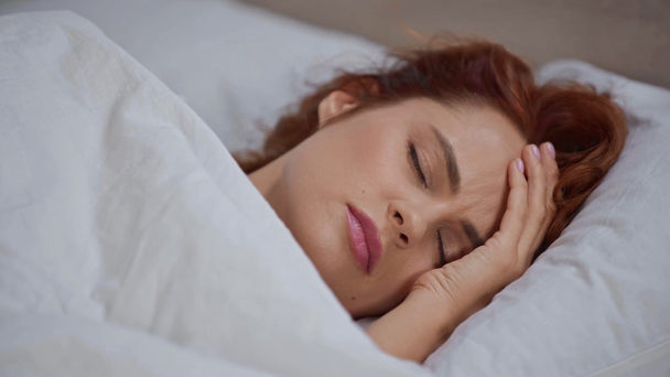 giovane donna sdraiata sotto coperta e affetta da mal di testa
  - Filmati, video