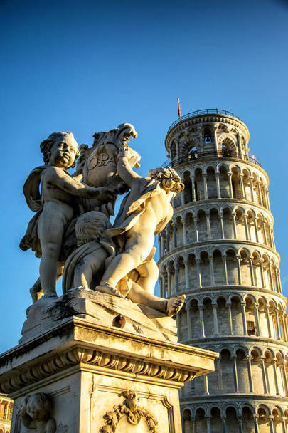 The putti in front of the leaning tower of Pisa at sunset - Foto, imagen