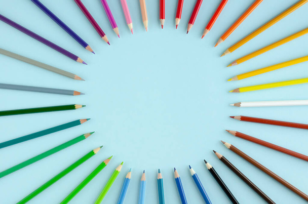 Colored pencils composition on blue background. Flat lay. - 写真・画像