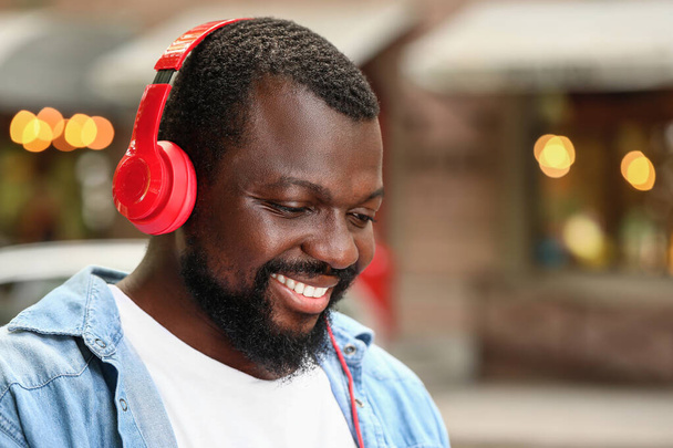 屋外で音楽を聴くハンサムなアフリカ系アメリカ人の男性 - 写真・画像