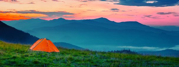 日没時の山の中のオレンジテント - 写真・画像