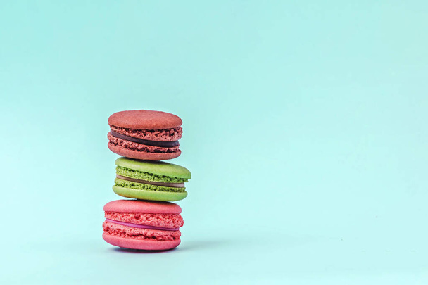 Assorted colorful macaroons on mint green background with copy space. - Фото, зображення