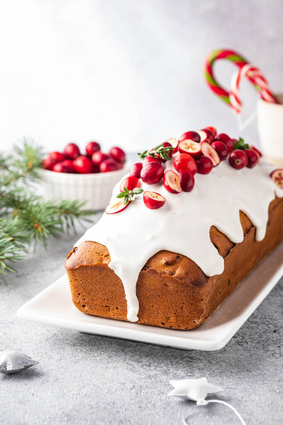 Christmas cake with cranberries and Christmas decorations on a gray background. - 写真・画像