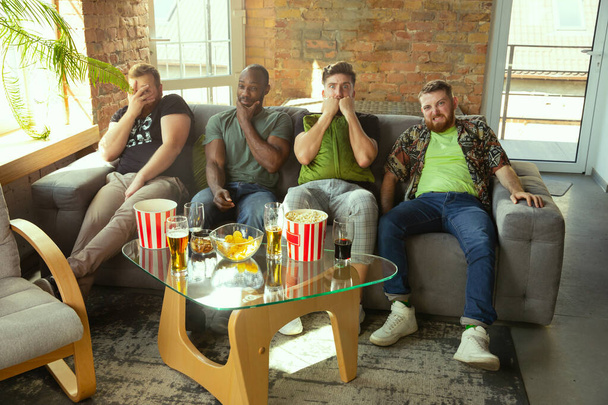 Group of friends watching football or soccer game on TV at home - Fotó, kép