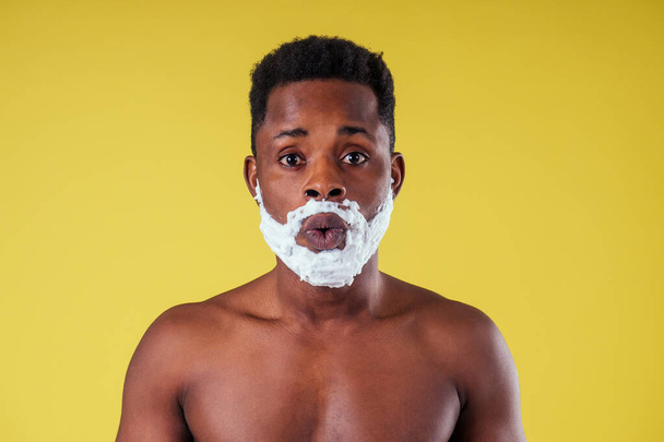 African-american man with razor and shaving foam on his face - Фото, изображение