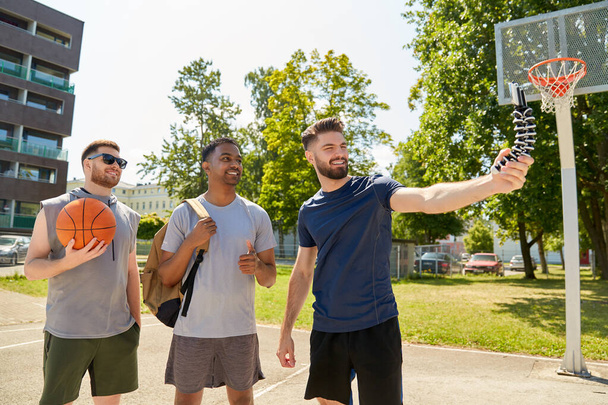 happy men taking selfie on basketball playground - 写真・画像