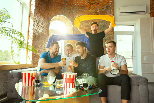 Group of friends watching football or soccer game on TV at home - Photo, image