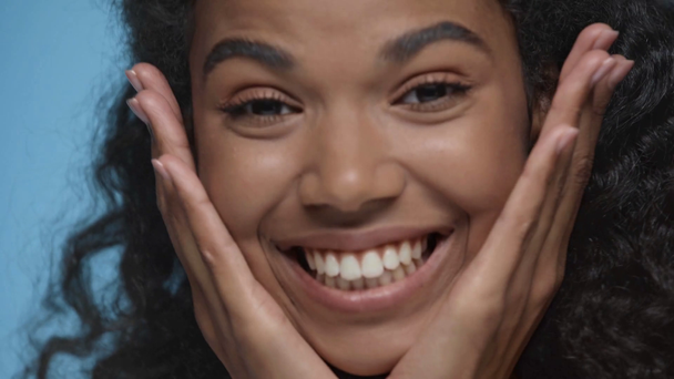close-up uitzicht van gelukkig Afrikaans amerikaanse vrouw geïsoleerd op blauw - Video