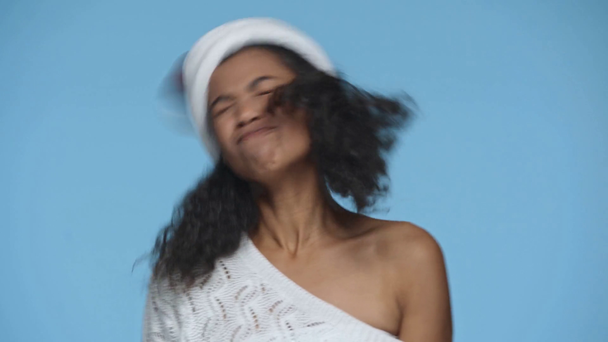 speelse gelukkig Afrikaans amerikaanse vrouw in Santa hoed dansen geïsoleerd op blauw - Video