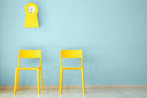 Сучасні стільці біля кольорової стіни
 - Фото, зображення