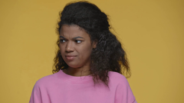 незадоволена афроамериканська дівчина, яка не показує жодного жесту ізольовано на жовтому
 - Кадри, відео