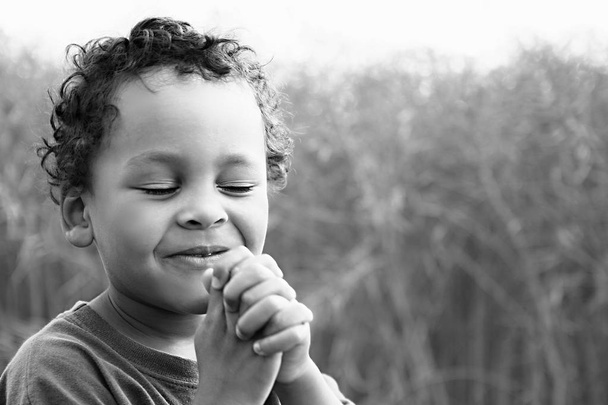 Kleiner Junge betet zu Gott Aktienbild mit zusammengehaltenen Händen Aktienfoto - Foto, Bild