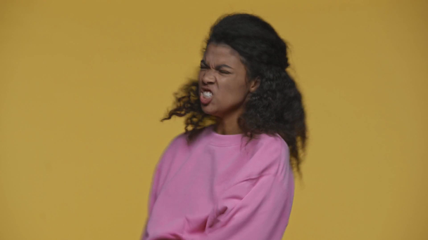 怒ったアフリカ系アメリカ人の少女が黄色に隔離されたスマートフォンを投げ - 映像、動画