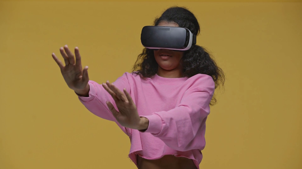 scared african american girl in vr headset isolated on yellow - Footage, Video