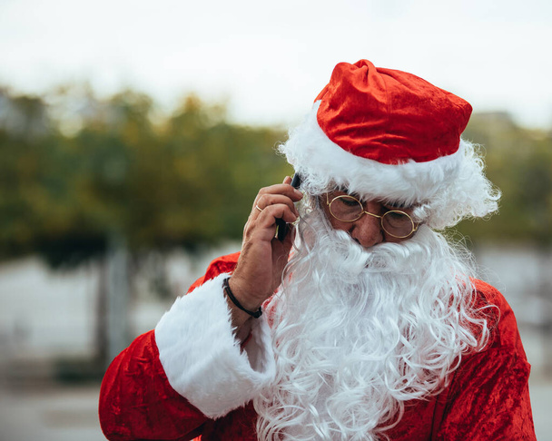 Santa Claus hablando con un teléfono móvil
 - Foto, Imagen