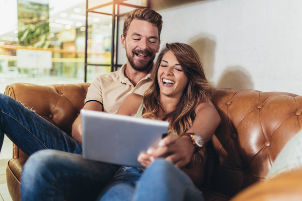 Flirting couple in cafe using digital tablet - Фото, изображение