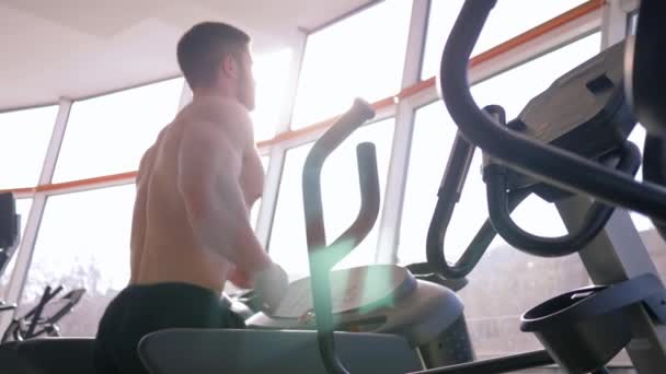 здоровый образ жизни, голый спортсмен с большими мускулами, бегающий на беговой дорожке во время кардиотренировки в спортзале у окна при ярком естественном свете
 - Кадры, видео