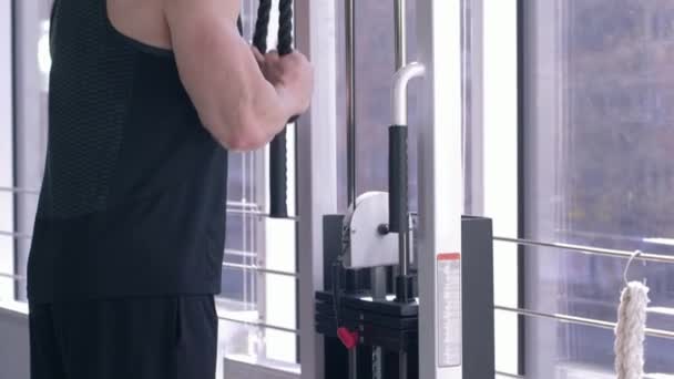 musculoso hombre deportivo fuerte realiza un ejercicio para el entrenamiento de musculación en simulador de tracción mientras trabaja en el cuerpo en el centro deportivo
 - Imágenes, Vídeo