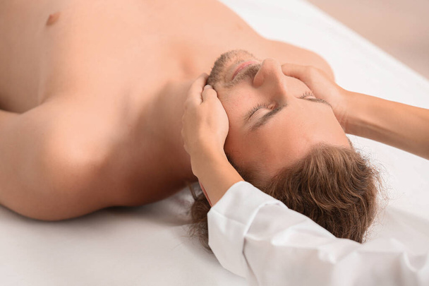 Jovem recebendo massagem facial no salão de spa
 - Foto, Imagem