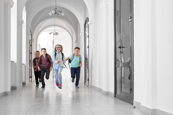 Boldog osztálytársak futnak az iskolában az órák után. - Fotó, kép
