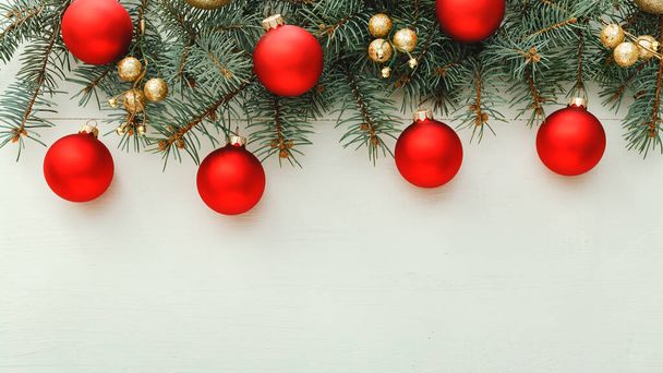 Xmas New Year 2020 різдвяний візерунок з червоних кульок, фір гілок на білому дерев'яному фоні. Concept Christmas time, winter.Flat lay, top view, copy space, long banner format - Фото, зображення