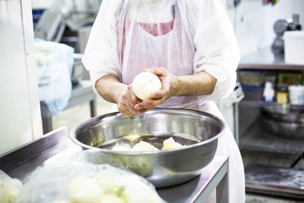 Food production, stages of food preparation. The cook cuts the onion - Photo, Image