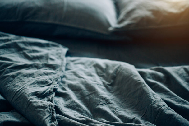 Blue bed sheets and pillows after night's sleep. - Foto, afbeelding