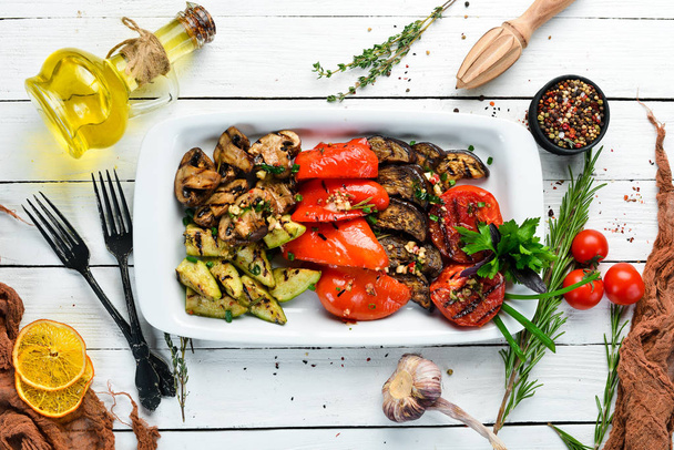 Grilled vegetables on a plate. Tomatoes, eggplants, mushrooms, zucchini. Dishes, food. Top view. Free space for your text. - Foto, Bild