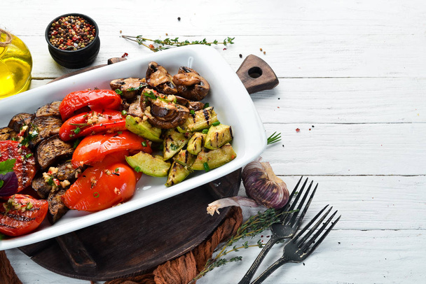 Grilled vegetables on a plate. Tomatoes, eggplants, mushrooms, zucchini. Dishes, food. Top view. Free space for your text. - Фото, изображение