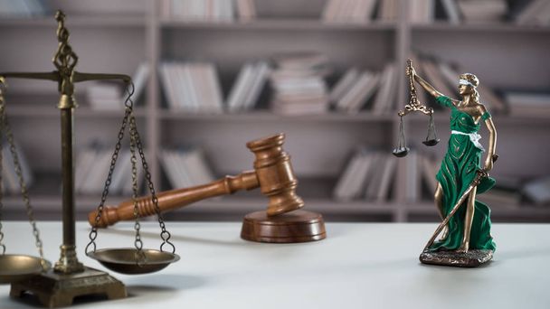 Натюрморт с символикой закона и справедливости на деревянном столе с размытым фоном книг
. - Фото, изображение