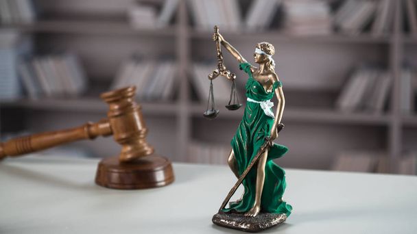 Натюрморт слепой богини Фемиды с молотком - Закон и справедливость символы на столе
 - Фото, изображение