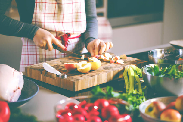 rajattu kuva nuori nainen ruoanlaitto täytetyt ankka keittiössä
 - Valokuva, kuva