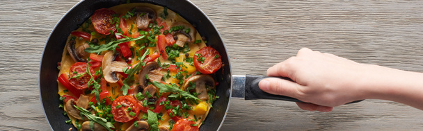 cropped view of woman cooking omelet with mushrooms, tomatoes and greens on frying pan - Φωτογραφία, εικόνα