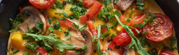 top view of yummy homemade omelet with mushrooms, tomatoes and greens - Foto, immagini