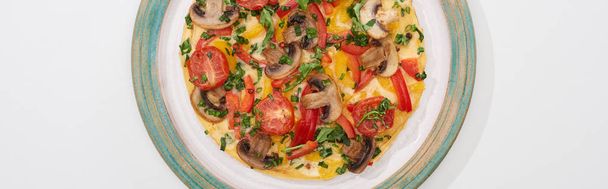 top view of plate with tasty omelet with tomatoes and mushrooms for breakfast on white table  - 写真・画像
