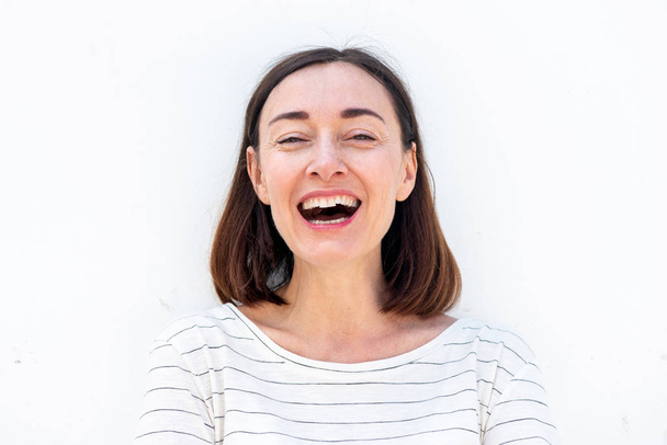 Primer plano retrato de atractiva mujer mayor riendo por fondo blanco
 - Foto, Imagen