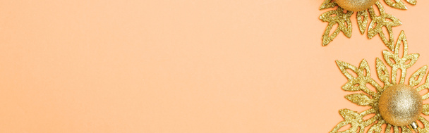 panoramic shot of golden Christmas decoration on orange background with copy space - Fotó, kép
